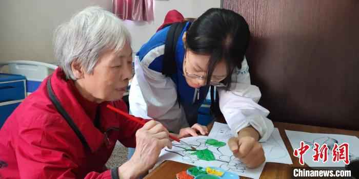 护理学院的志愿者们陪公寓老人绘画。供图