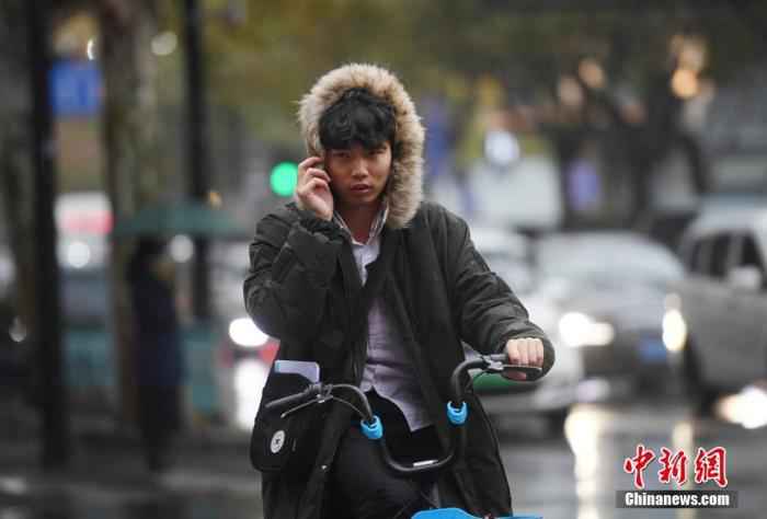 资料图：降温天气下，市民着冬装出行。/p中新社记者 王刚 摄