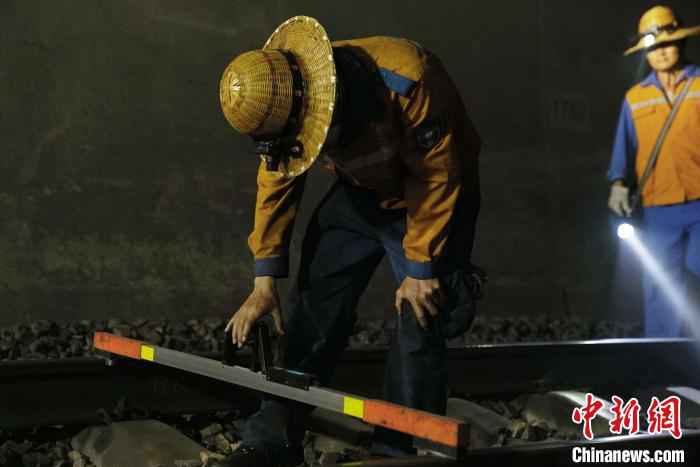 图为线路工用手工电子道尺检查铁轨。　吴宇 摄