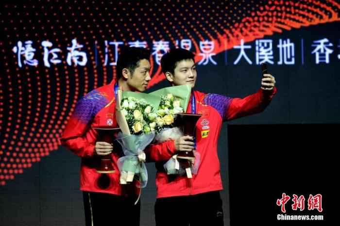 12月15日,在河南郑州进行的2019国际乒联世界巡回赛总决赛男子双打决赛中,中国组合樊振东/许昕以3比1战胜中国台北组合廖振珽/林昀儒,夺得冠军。图为樊振东(右)、许昕在领奖台上用手机自拍。中新社记者 王中举 摄 国乒、国羽漂亮收官不代表高枕无忧