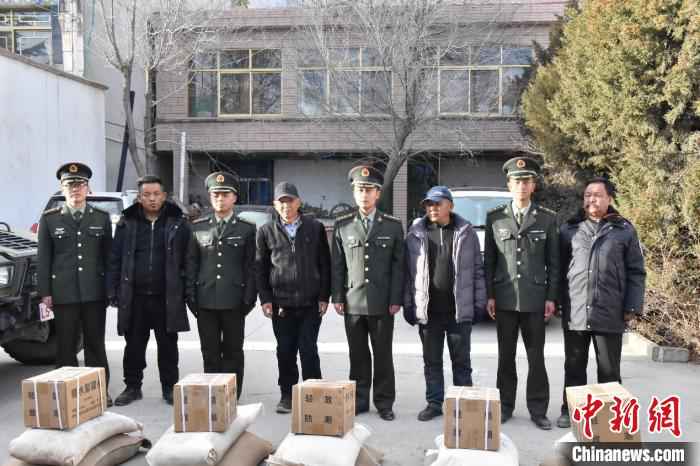 图为官兵与社区民众合影。 黄林 摄 寒冬送温暖 驻藏官兵走访慰问驻地民众