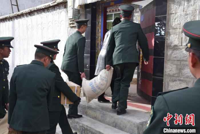 图为官兵为居民送上慰问品。 黄林 摄 寒冬送温暖 驻藏官兵走访慰问驻地民众
