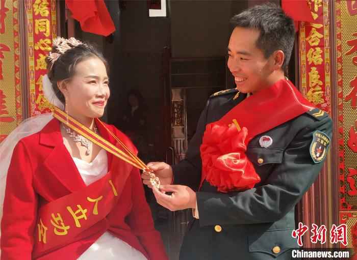 杨学德为妻子李云艳戴上军功章 周晓星 摄 爱情和军功章都给你:火箭军新人婚礼现场收立