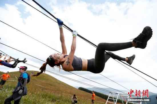 资料图:8月24日,2019英菲尼迪斯巴达勇士亚太区锦标赛在河北张家口崇礼开赛,本次比赛包含竞速赛、超级赛、超级野兽赛等六个级别的赛事,吸引了全球44个国家和地区的15000余名中外勇士参与。其中参加超级野兽赛的选手将在51公里长的赛道上挑战奥林匹斯之巅、胜利之矛、人猿泰山、海格力斯之臂等67个障碍。斯巴达勇士赛起源于2005年,是一项吸收了古斯巴达人军事项目的主题越野跑赛事。图为选手通过生命之绳障碍。 中新社记者 富田 摄 爬泥地、跨明火、越障碍……中国人也能当斯巴