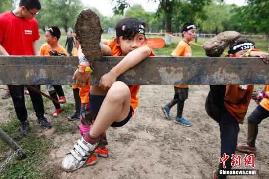 资料图:6月1日,一名小朋友在比赛中。当日是“六一”国际儿童节,2019斯巴达勇士儿童赛北京站在京举行,近万名小勇士将在为期两天的比赛中挑战自我。中新社记者 富田 摄 爬泥地、跨明火、越障碍……中国人也能当斯巴