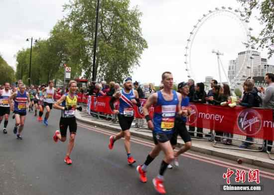 资料图:第39届伦敦马拉松比赛。图为选手们在比赛中经过伦敦标志性建筑“伦敦眼”。 中新社记者 张平 摄 伦敦马拉松延期至10月 5场大满贯赛事扎堆下半年
