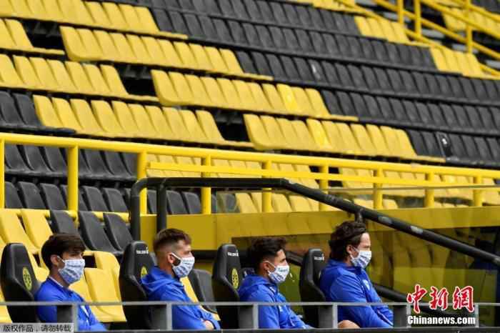 北京时间5月16日晚,德甲联赛在停摆两个多月之后终于重燃战火,成为疫情以来欧洲五大联赛最早开赛的代表。图为在多特蒙德与沙尔克04的比赛中,场边的替补球员都佩戴着口罩。 学习中超?德足协主席:可借疫情设置工资帽政