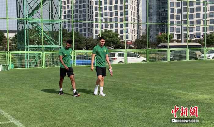 阿兰(左)出现在国安训练场。卞立群 摄 主帅海外“云执教” 北京国安为中超开赛枕戈待