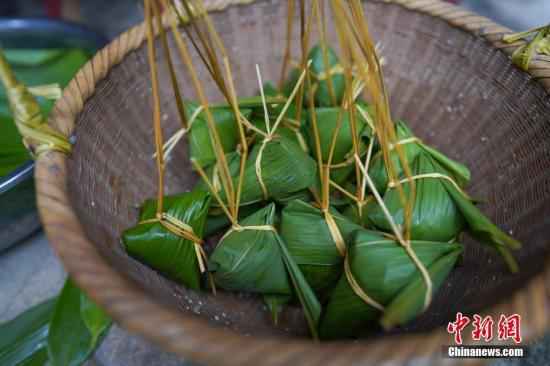 资料图:2019年6月6日,贵州黎平县三龙侗寨侗族妇女包的棕子。在当地,端午时节,侗族妇女采摘竹叶包粽子迎端午节,庆祝“关秧门”。中新社记者 贺俊怡 摄 涨姿势!端午吃粽子,如何既解馋又不胖?
