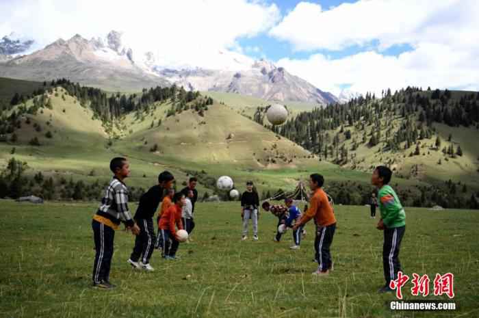 海拔近4000米的四川省甘孜藏族自治州理塘县格聂镇则巴村,雪山下一处草地上,13名格聂小学少年足球队的队员在老师的带领下,开展体能、运球、颠球等足球运动项目训练,一群藏族少年的足球梦想正在雪山下萌芽。 图为正在草地上训练的孩子们。 刘忠俊 摄 体坛观察丨中国足球不行,是因为球迷“反智”