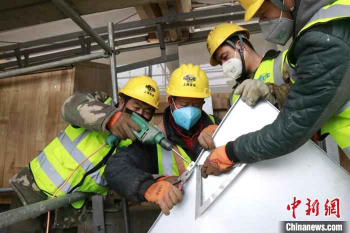 国家雪车雪橇中心工作人员正在进行赛道遮阳背板安装。北京市重大办供图 北京冬奥会延庆赛区今年年底将全面完工