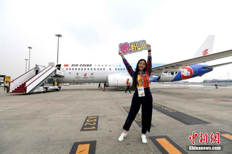 5日,国航“冬奥冰雪号”顺利落地成都双流国际机场。首航航班的旅客在机场拍照留念。 安源 摄 首飞顺利完成!首架冬奥主题彩绘航班被网友夸