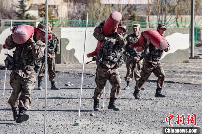 图为西藏军区某旅新兵扛着模拟“伤员”进行战场搬运考核。　西藏军区某旅 摄
